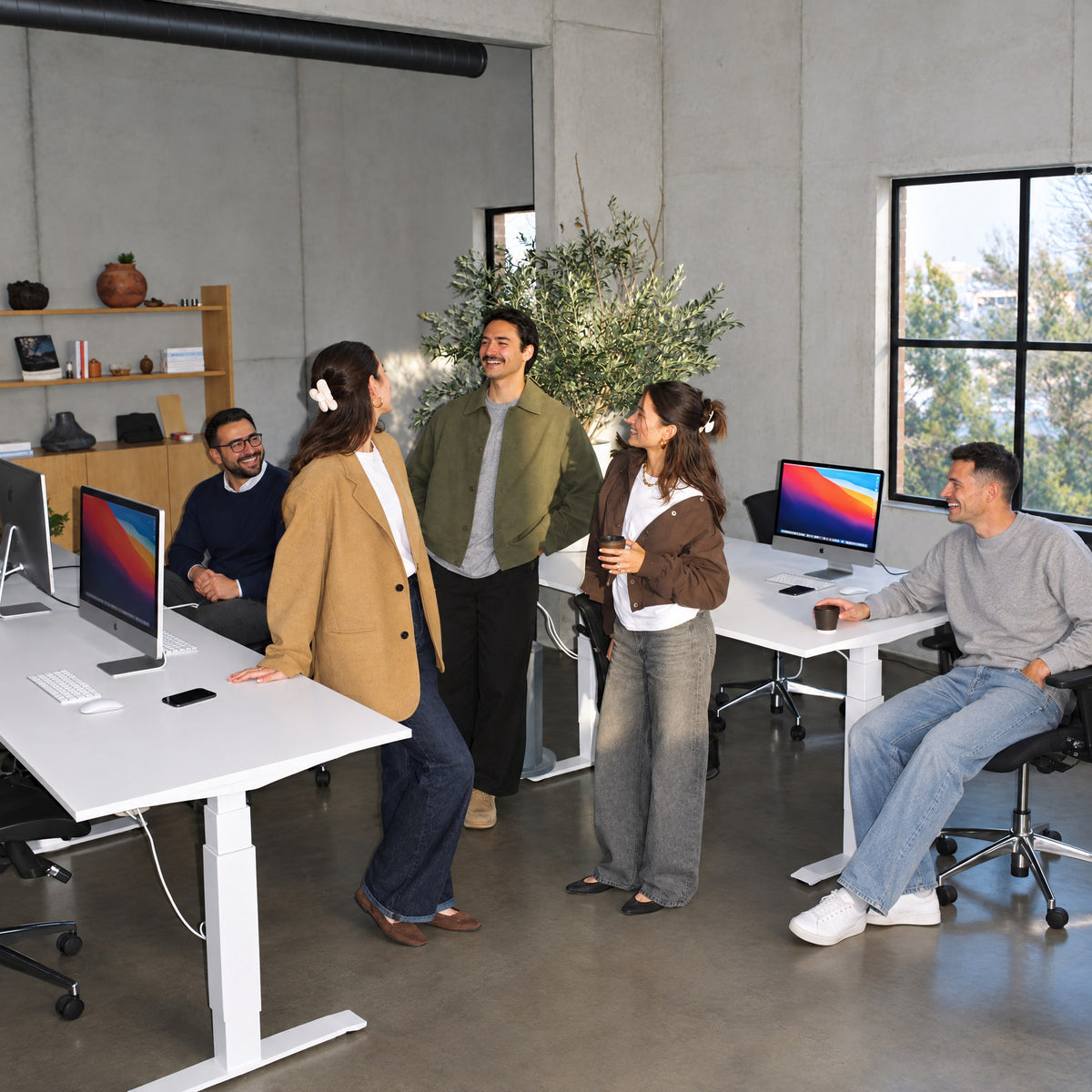Das DESKSPACE-Team im Büro an höhenverstellbaren Schreibtischen
